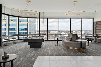 A modern room with a pool table and a view of the city.
